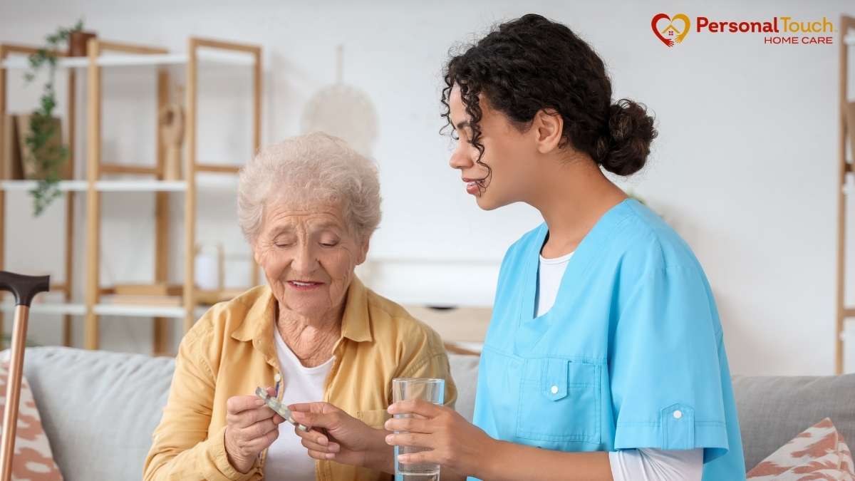 Caregiver helping an elderly woman take medication at home