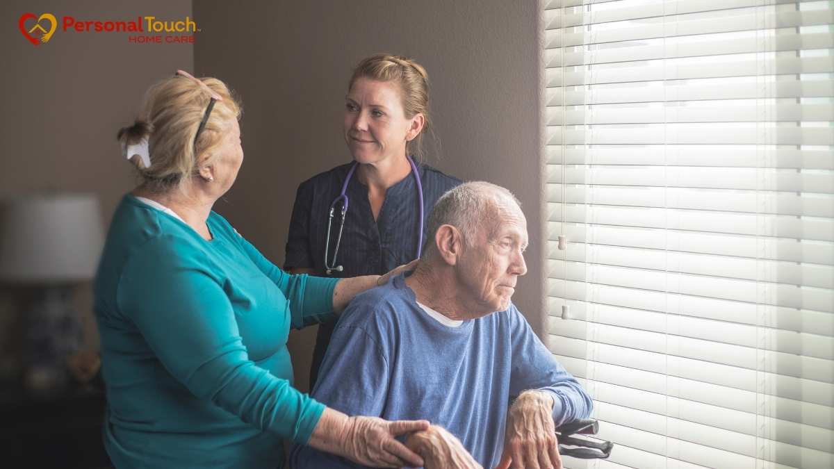 Nurse and family member supporting an elderly man at home