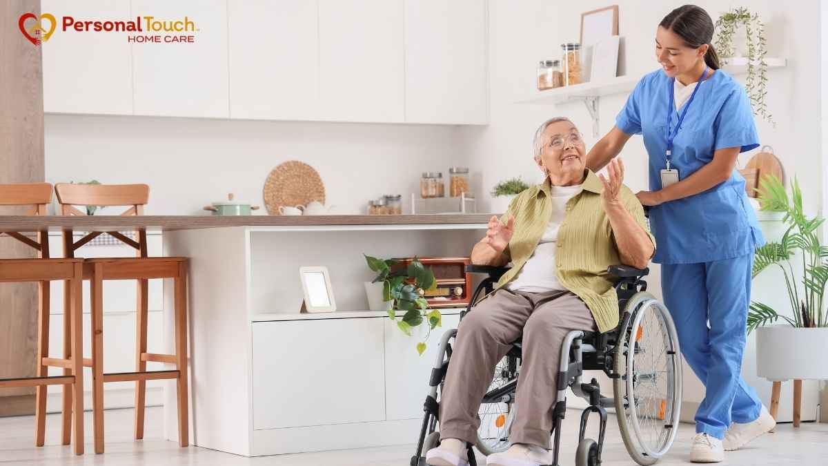 Nurse pushing a smiling elderly woman in a wheelchair at home