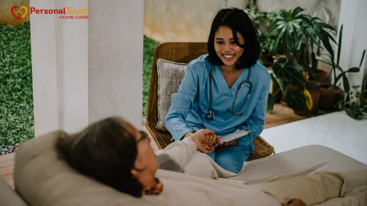 Smiling nurse holding a patient's hand during a home visit outdoors